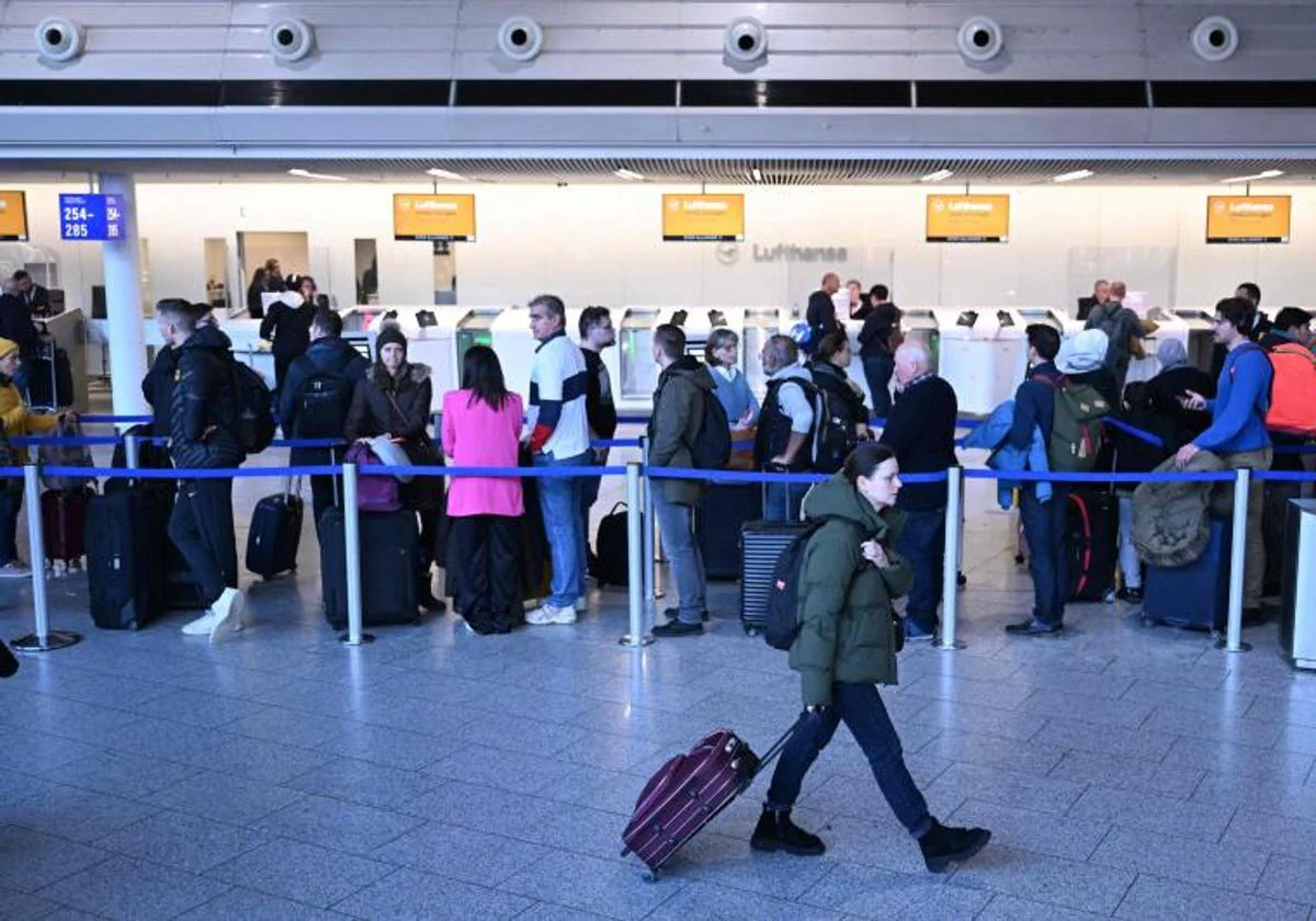 Los pasajeros caminan o hacen cola para cambiar la reserva cuando los vuelos se cancelan o retrasan en el aeropuerto de Frankfurt, Frankfurt am Main, Alemania occidental