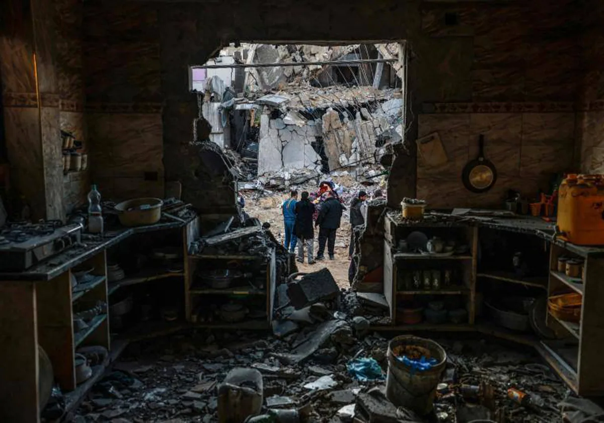 Gazatíes comprueban los daños a una vivienda tras el bombardeo israelí en Rafah, el sábado