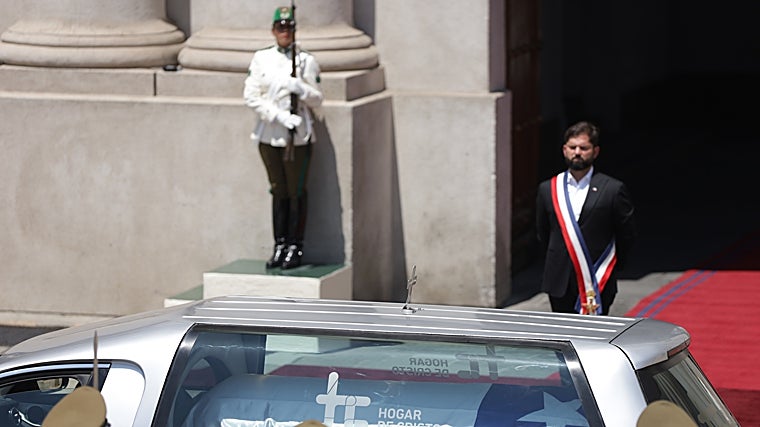 El presidente de Chile, Gabriel Boric, observa la carroza con el féretro del expresidente Sebastián Piñera a la llegada del cortejo fúnebre al Palacio de La Moneda