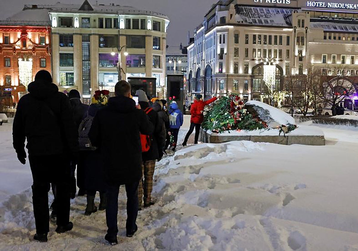 Decenas de personas depositando flores en un momento en homenaje a los represaliados políticos en Moscú