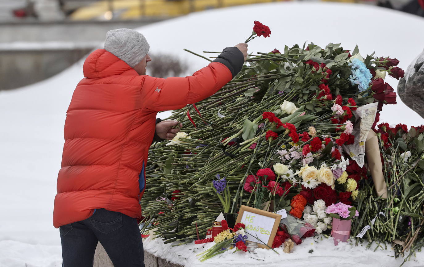 Un hombre pone flores de luto  cerca del monumento a los presos políticos en Moscú