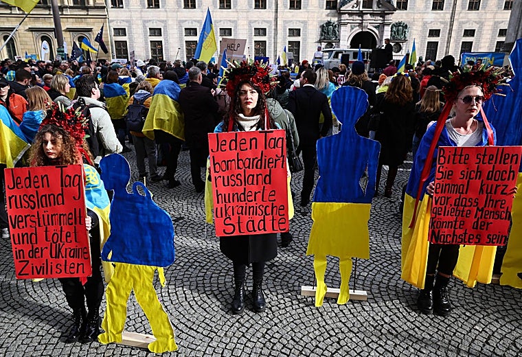Manifestantes sostienen carteles que dicen «cada día Rusia mutila y mata a civiles en Ucrania», «cada día Rusia bombardea cientos de ciudades» y «por favor imaginen un momento en el que tu ser querido podría ser el siguiente.' en una protesta en Múnich en el curso de Conferencia