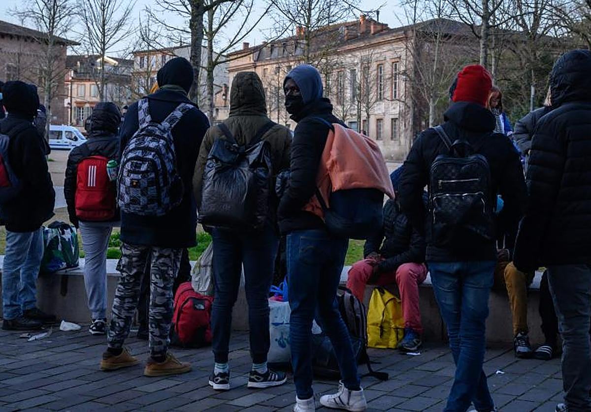 Los inmigrantes que se habían refugiado en un gimnasio se reúnen afuera después de ser desalojados por la policía, en el centro de Toulouse