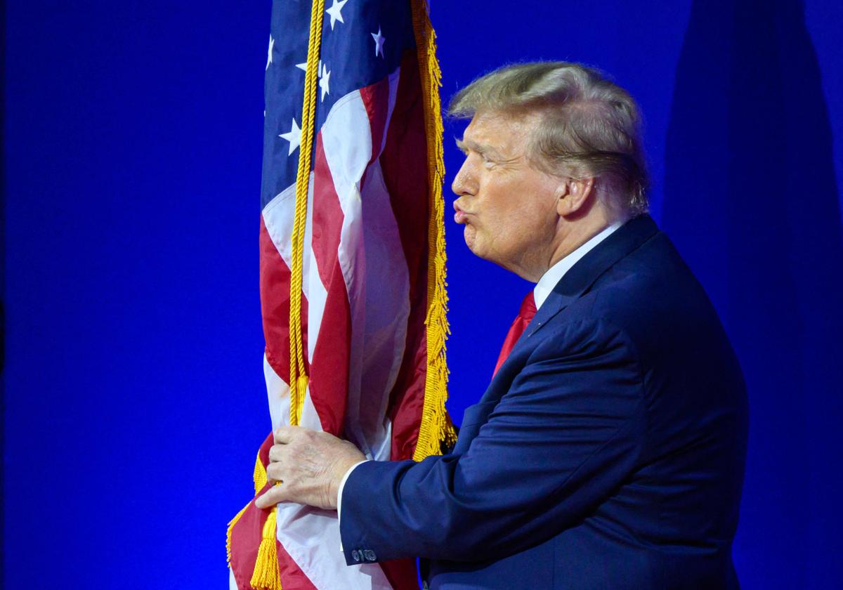 Donald Trump besa la bandera de los EE.UU.