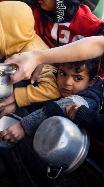 Niños palestinos esperan recibir comida en Rafah