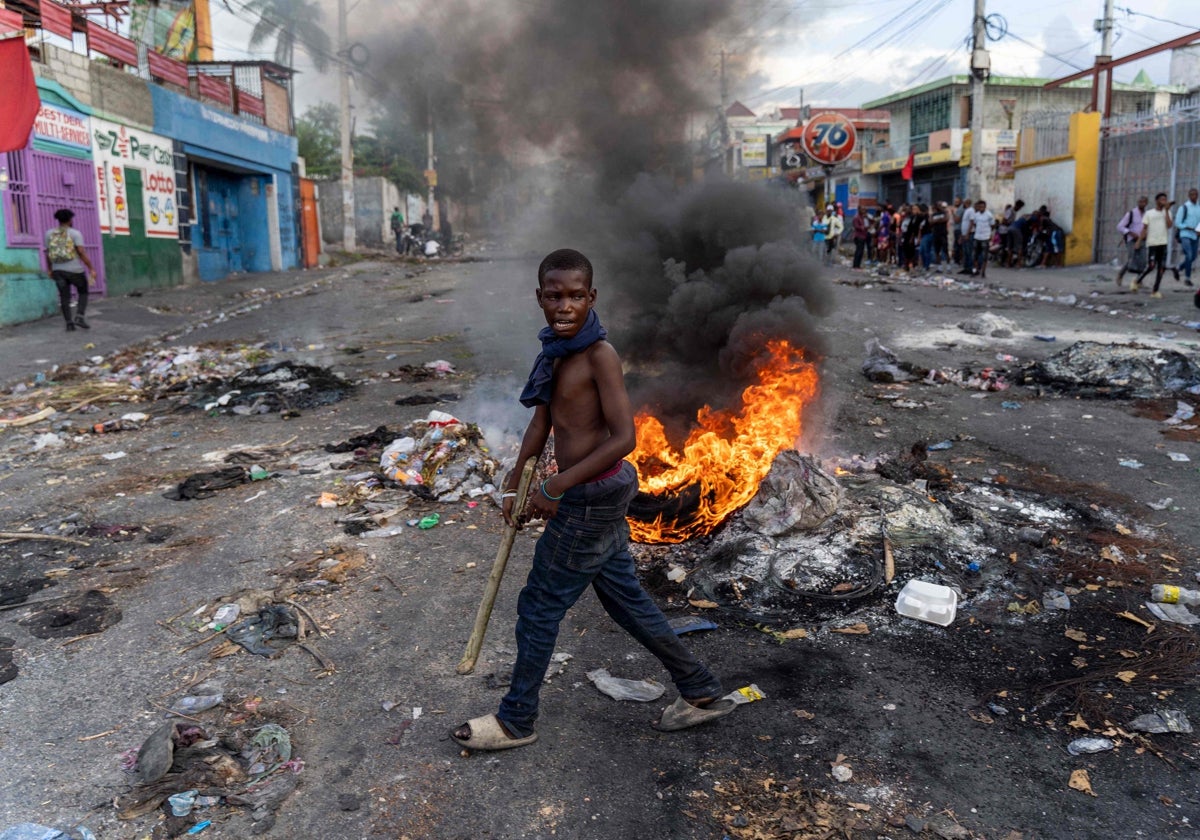 UN hombre pasa por delante de una barricada en llamas durante una protesta contra el Gobierno haitiano