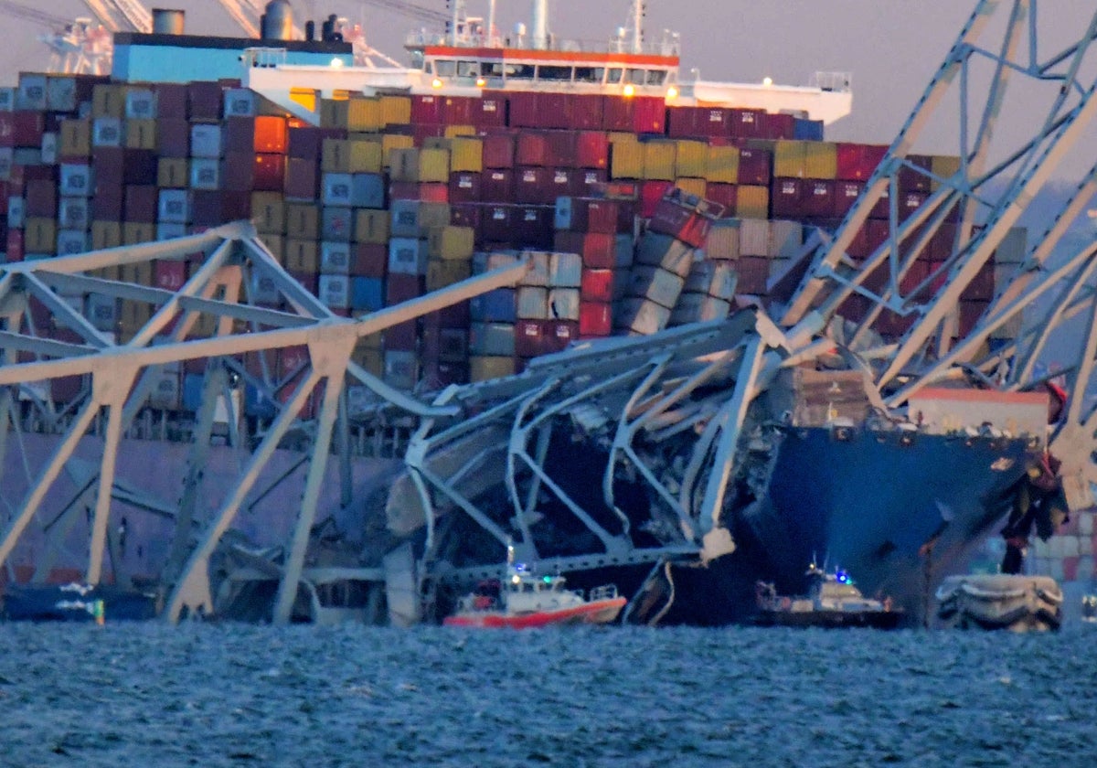 Barcos de emergencia flotan alrededor de un buque portacontenedores cuya proa sufrió daños tras el derrumbe del puente Francis Scott Key