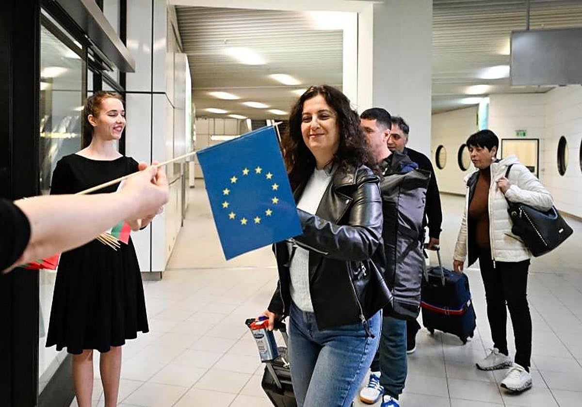 Pasajeros que llegan desde Berlín reciben las banderas de la Unión Europea y de Bulgaria durante la entrada parcial oficial de Bulgaria (por aire y por mar) en el espacio Schengen de fronteras abiertas de Europa por aire y mar en el aeropuerto de Sofía