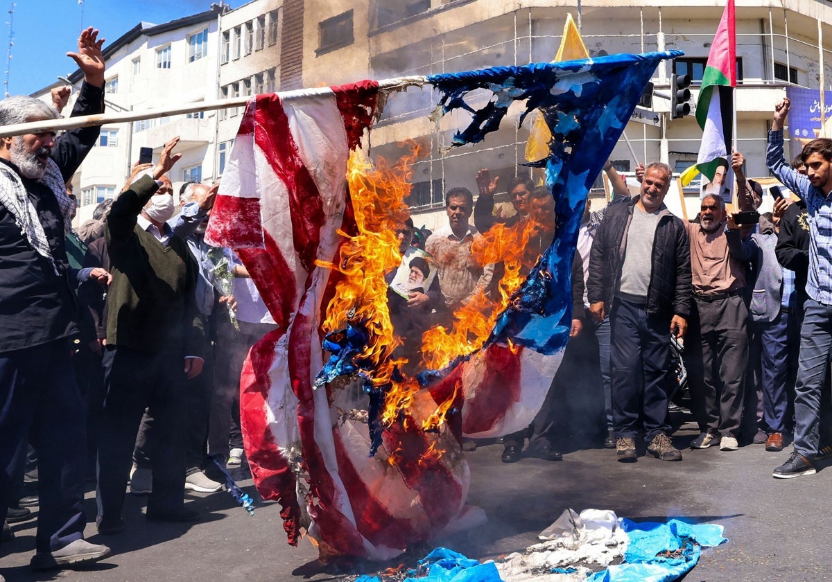 Manifestantes queman una bandera estadounidense y otra israelí en Teherán