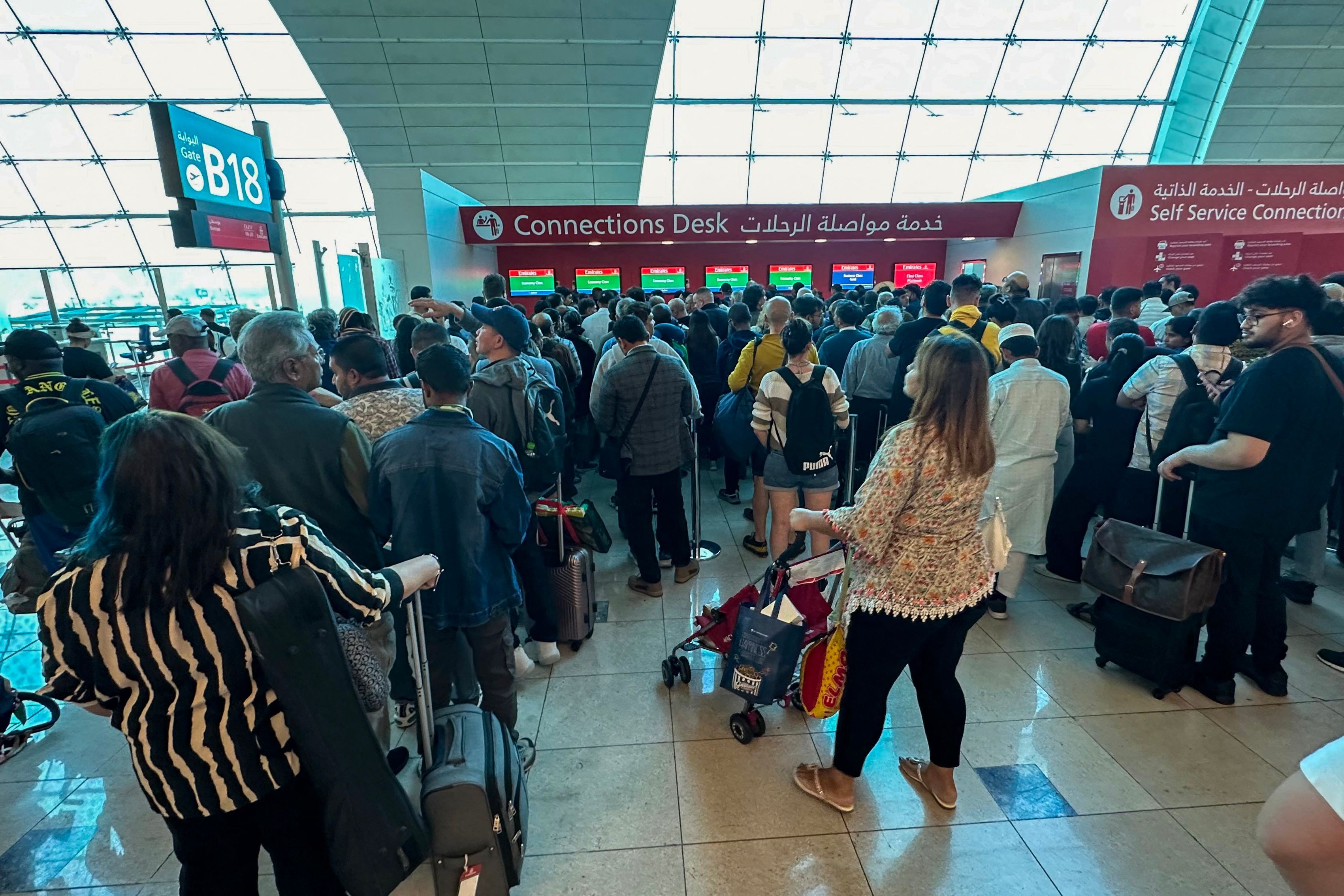 Varios viajeros esperan en el aeropuerto de Dubái, que ha suspendido sus operaciones este miércoles. 
