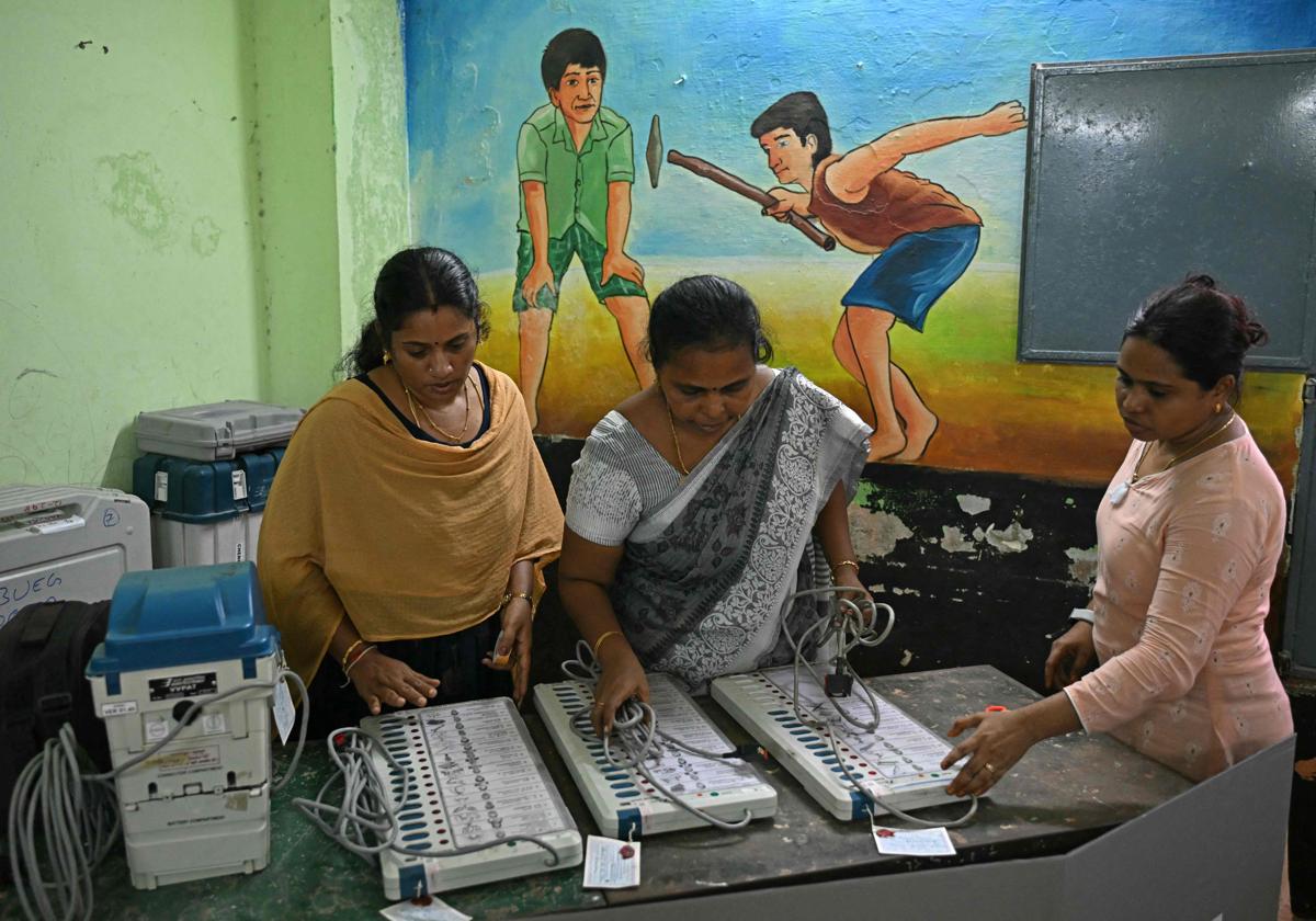 Los funcionarios trabajan en la máquina de votación electrónica (EVM) en vísperas de la primera fase de la votación