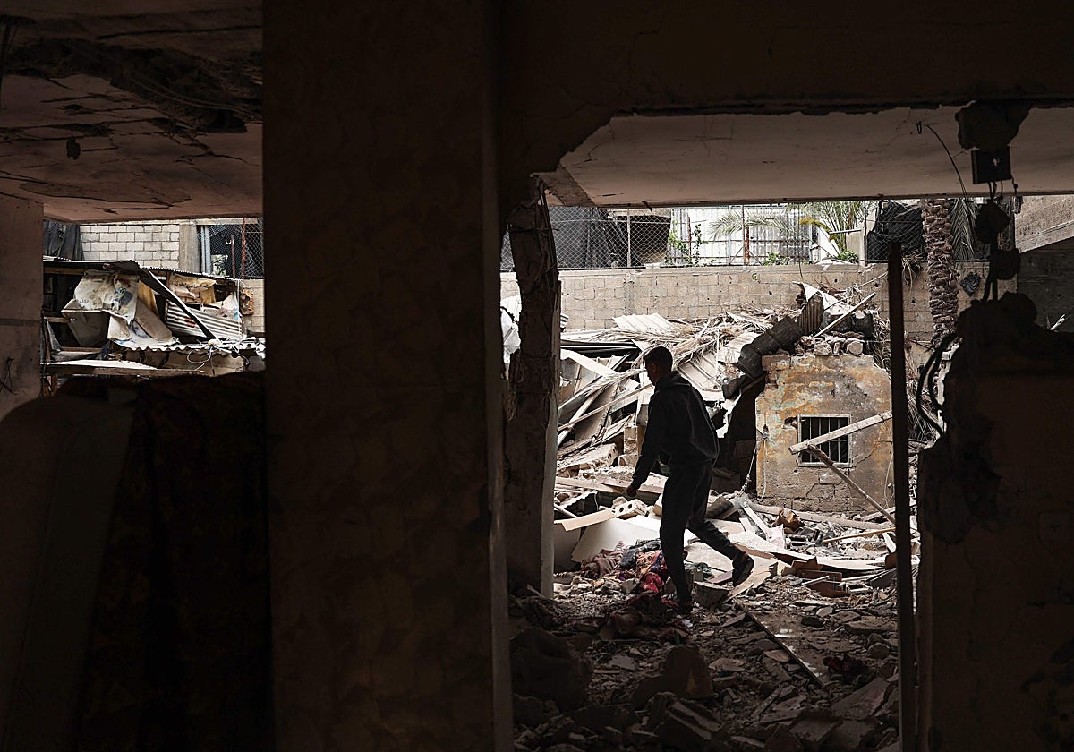 Un hombre comprueba los daños en una casa destruida por el bombardeo israelí nocturno en Rafah