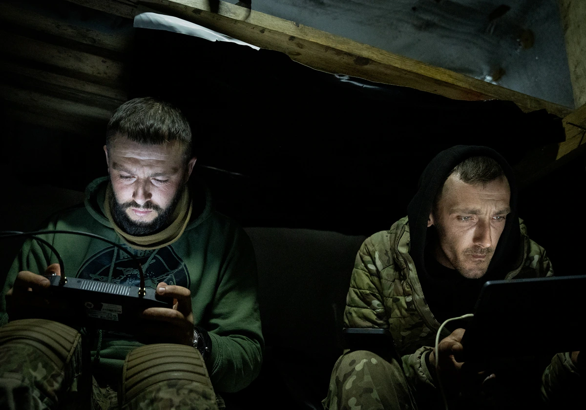 Roman pilotando el dron y Vania asistiendo en la navegación, dentro de un refugio en la segunda línea del frente