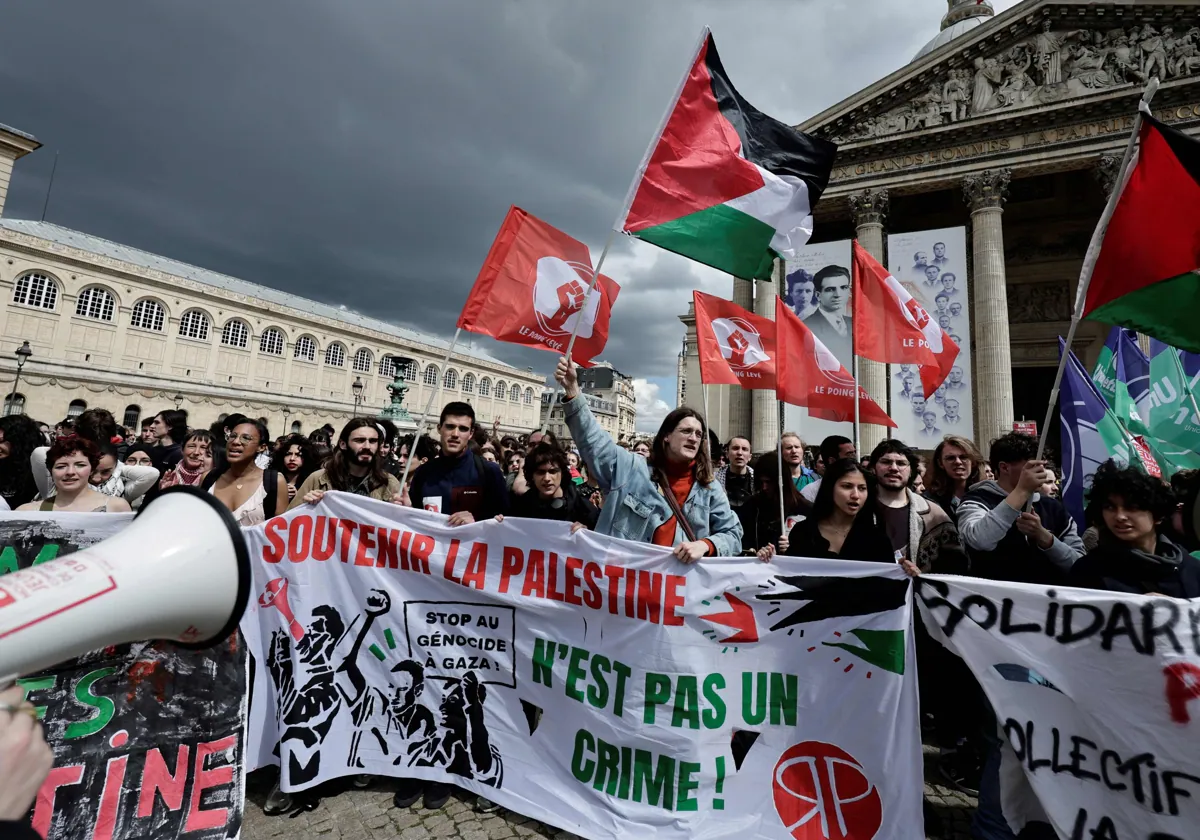 Varios estudiantes sostienen pancartas y protestan en París en apoyo a los palestinos