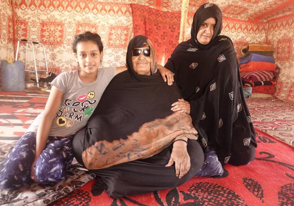 Lamina (en el centro), su hija Jade y su nieta Maga en el campo de refugiados de Auserd