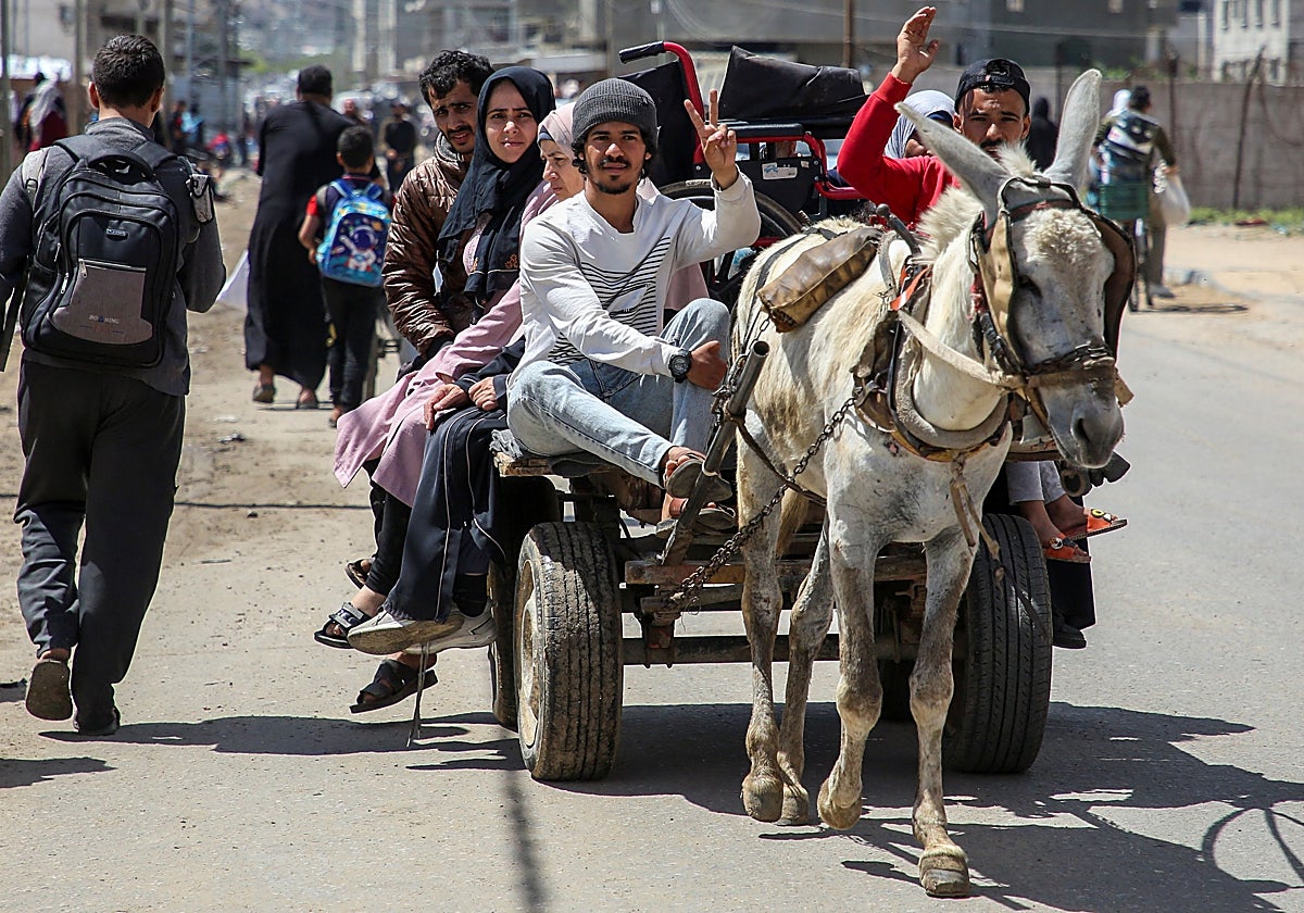 Un grupo de palestinos huye con sus pertenencias de los barrios de Rafah que van a ser bombardeados