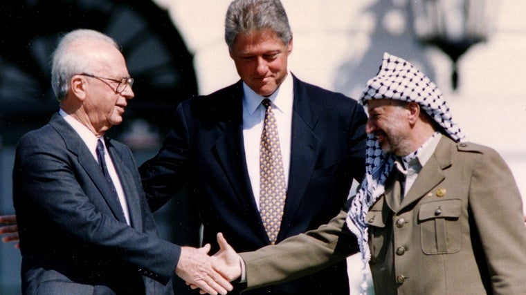 El fallecido ex primer ministro israelí Isaac Rabin estrecha la mano de Yaser Arafat con Bill Clinton de fondo en septiembre de 1993