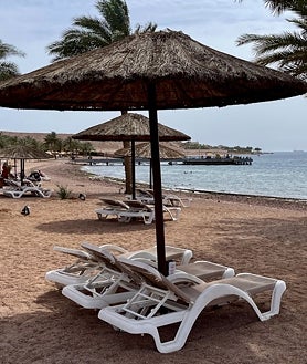 Imagen secundaria 2 - Otro de los destinos más populares de Jordania, el mar Rojo, también ha sufrido una drástica reducción de turistas, primero por la guerra en Gaza y ahora por el ataque de Irán contra Israel con cientos de misiles y drones en abril. Así se aprecia en hoteles y complejos de vacaciones de lujo como Grand Tala Bay (imagen superior), en los restaurantes y tiendas de suvenires que pueblan la carretera de Amán a Áqaba (arriba a la izquierda) y en sus playas de arena blanca y fondos de coral (arriba a la derecha), que están desiertas