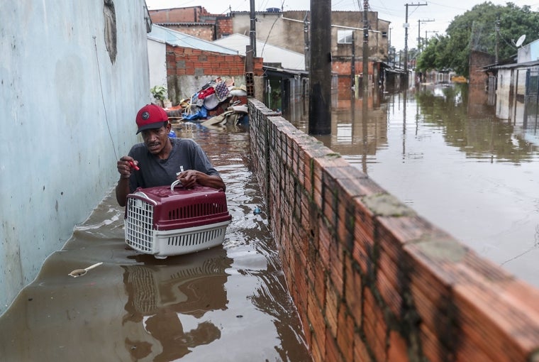 Wagner Souza sale de su casa inundada acompañado de su gato Lilico