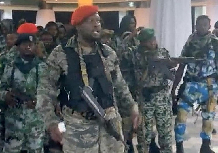 Un hombre vestido con uniforme militar habla mientras otros están junto a él dentro del Palacio de la Nación durante un intento de golpe en Kinshasa