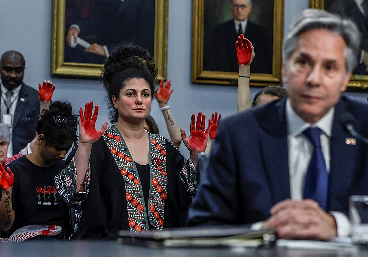 El secretario de Estado de Estados Unidos, Antony Blinken, comparece con una protesta propalestina al fondo