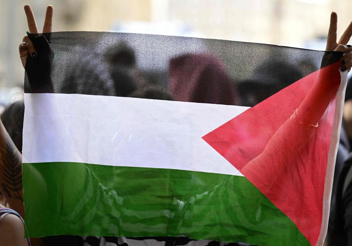 Un manifestante sostiene una bandera palestina frente a la Universidad Humboldt durante una protesta pro-palestina en Berlín