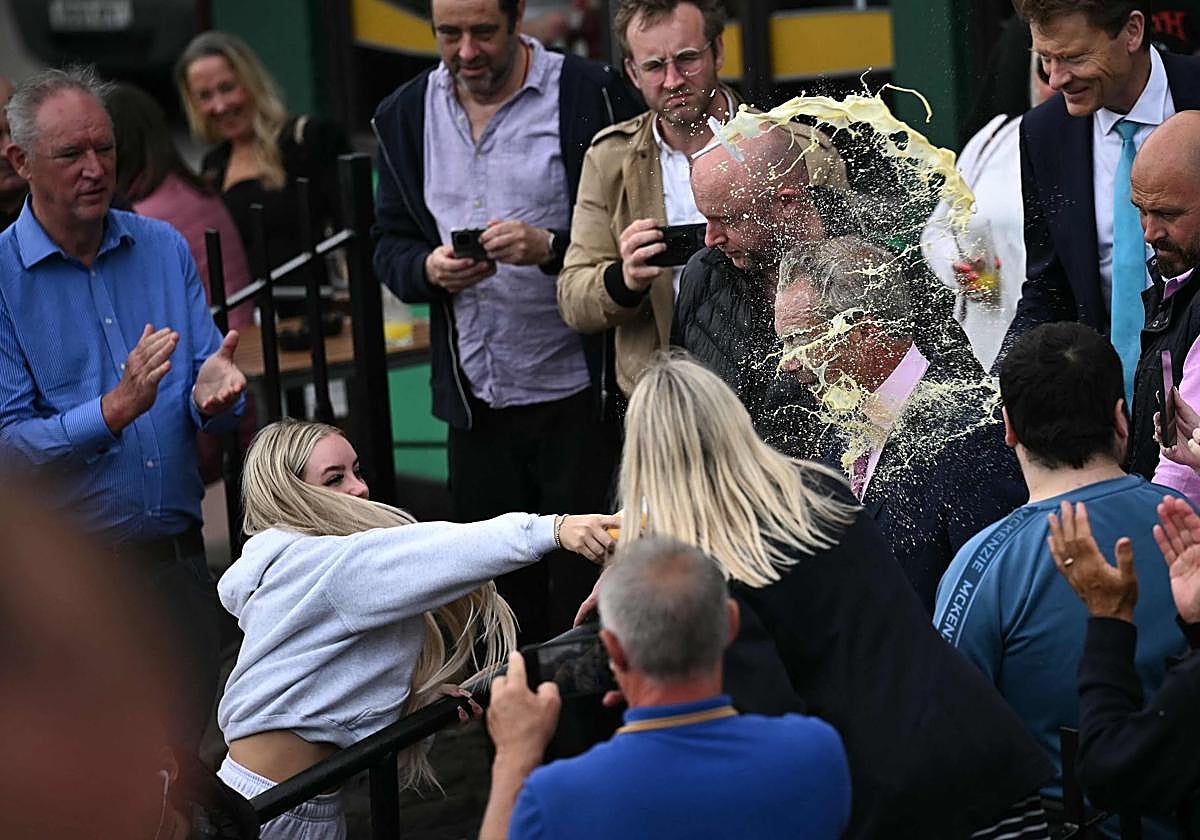 Momento en el que una joven lanza un batido a Nigel Farage