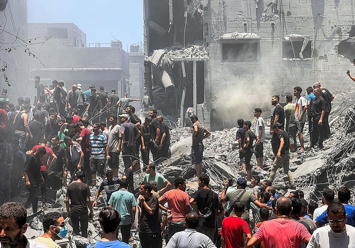 Palestinos buscan víctimas en el lugar de los ataques israelíes contra casas, en la ciudad de Gaza