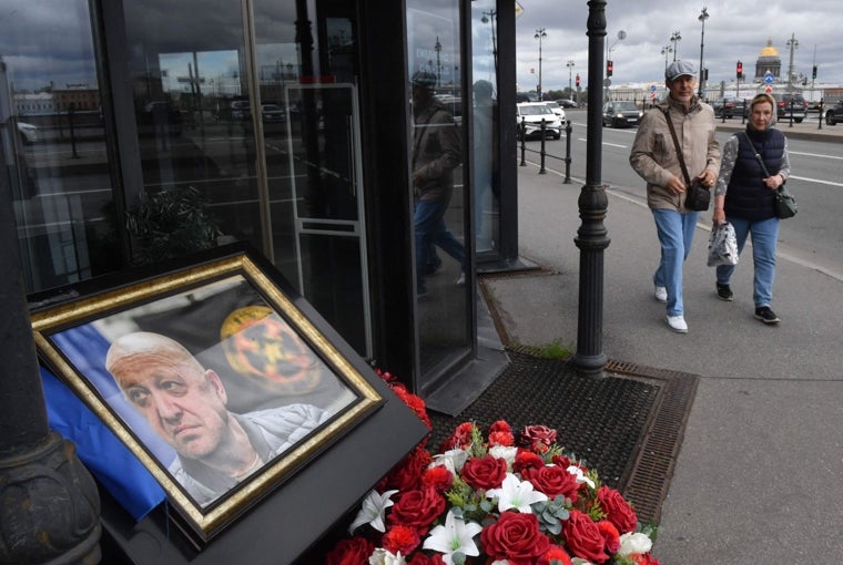 Transeúntes pasan frente a un monumento improvisado a Prigozhin cerca del café que poseía en San Petesburgo, el 20 de junio de 2024