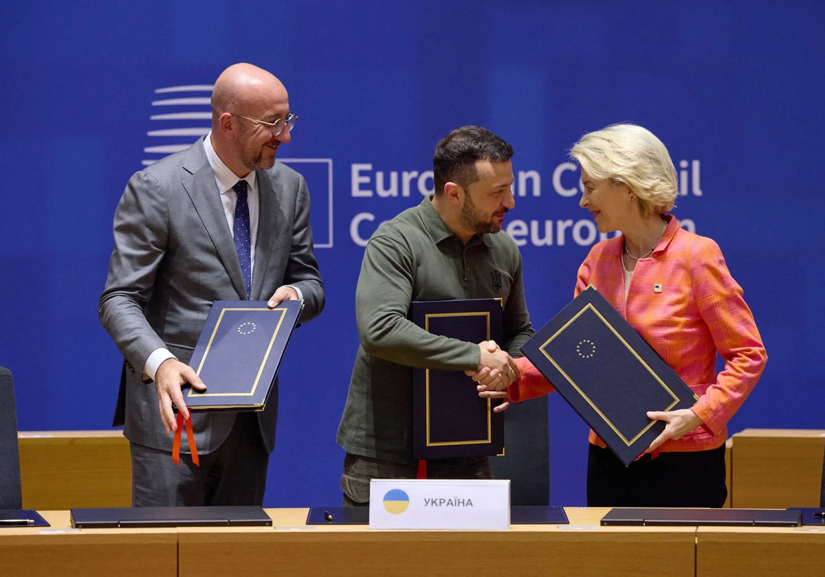 El presidente ucraniano Volodímir Zelenski estrecha la mano de la presidenta de la Comisión Europea, Ursula von der Leyen, tras firmar acuerdos de seguridad con la UE