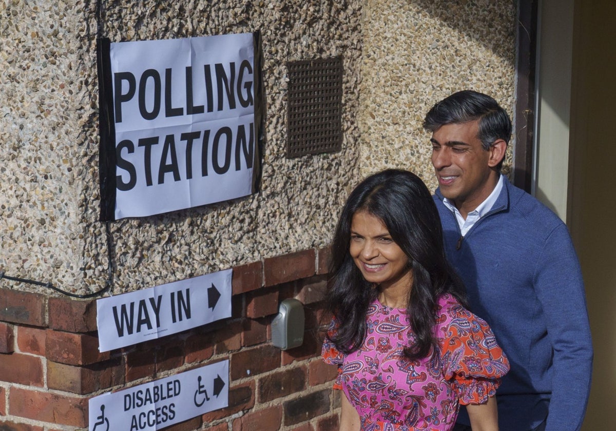 Rishi Sunak y su esposa, Akshata Murty, salen de un colegio electoral tras votar durante las elecciones generales británicas