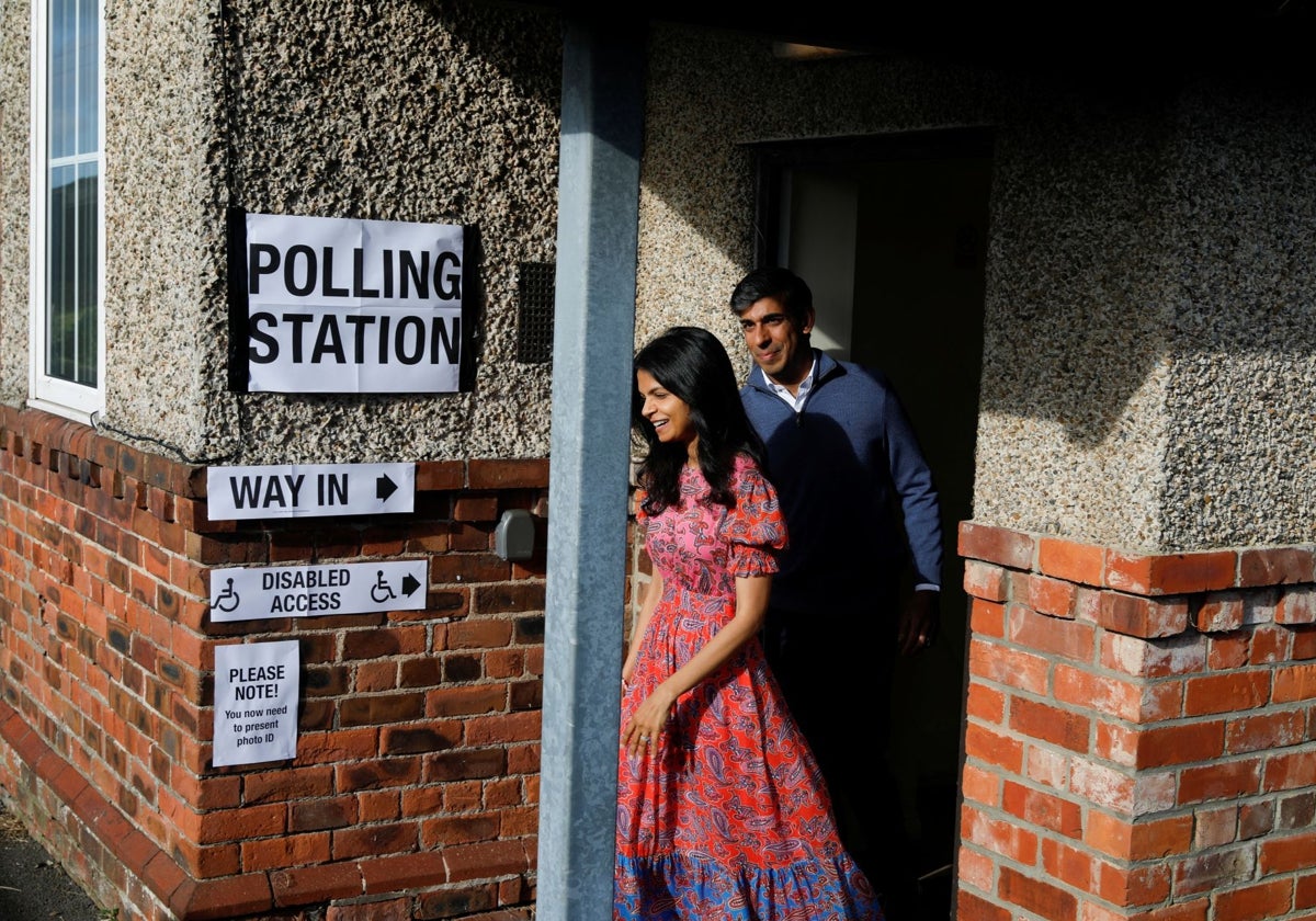 Rishi Sunak, y su esposa Akshata Murty caminan fuera de un colegio electoral