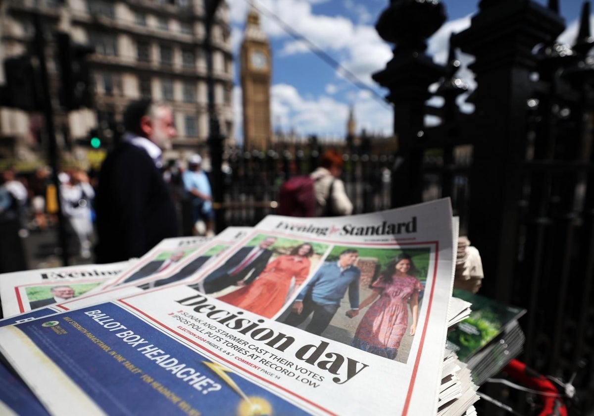 Peatones pasean por Westminster cerca de un quiosco que anuncia el día de las elecciones en la prensa