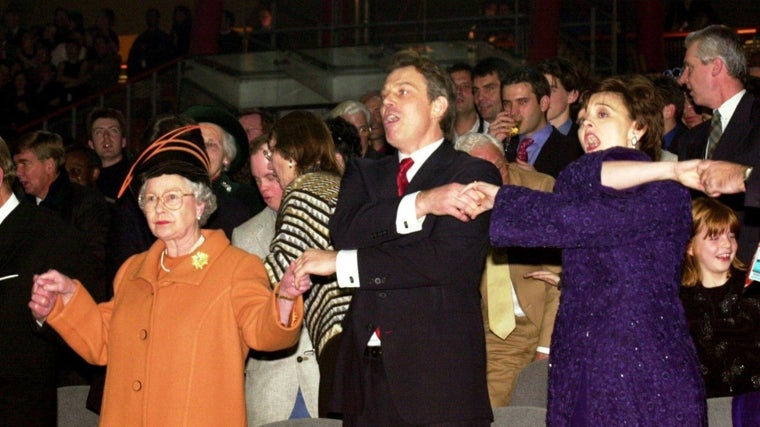 Isabel II, Tony Blair y su esposa Cherie entonan la canción escocesa de despedida 'Auld Lang Syne', en la Nochevieja de 1999