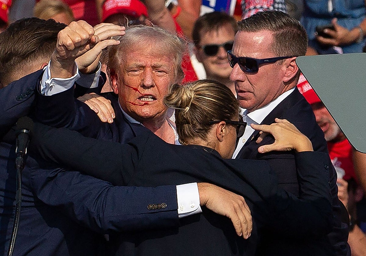 Trump rodeado de agentes del Servicio Secreto mientras es escoltado fuera del escenario