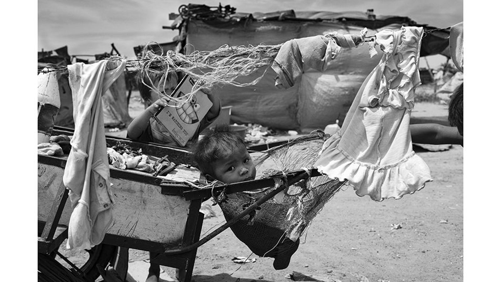 Maicao (Colombia), 16 de abril de 2021. El nieto de doña María Rosario Polanco descansa en una cuna improvisada en un carro callejero en el asentamiento conocido como La Pista. Este lugar, uno de los mayores asentamientos ilegales de migrantes venezolanos en Colombia, albergaba a más de 7,000 familias con un promedio de 5 miembros por hogar.