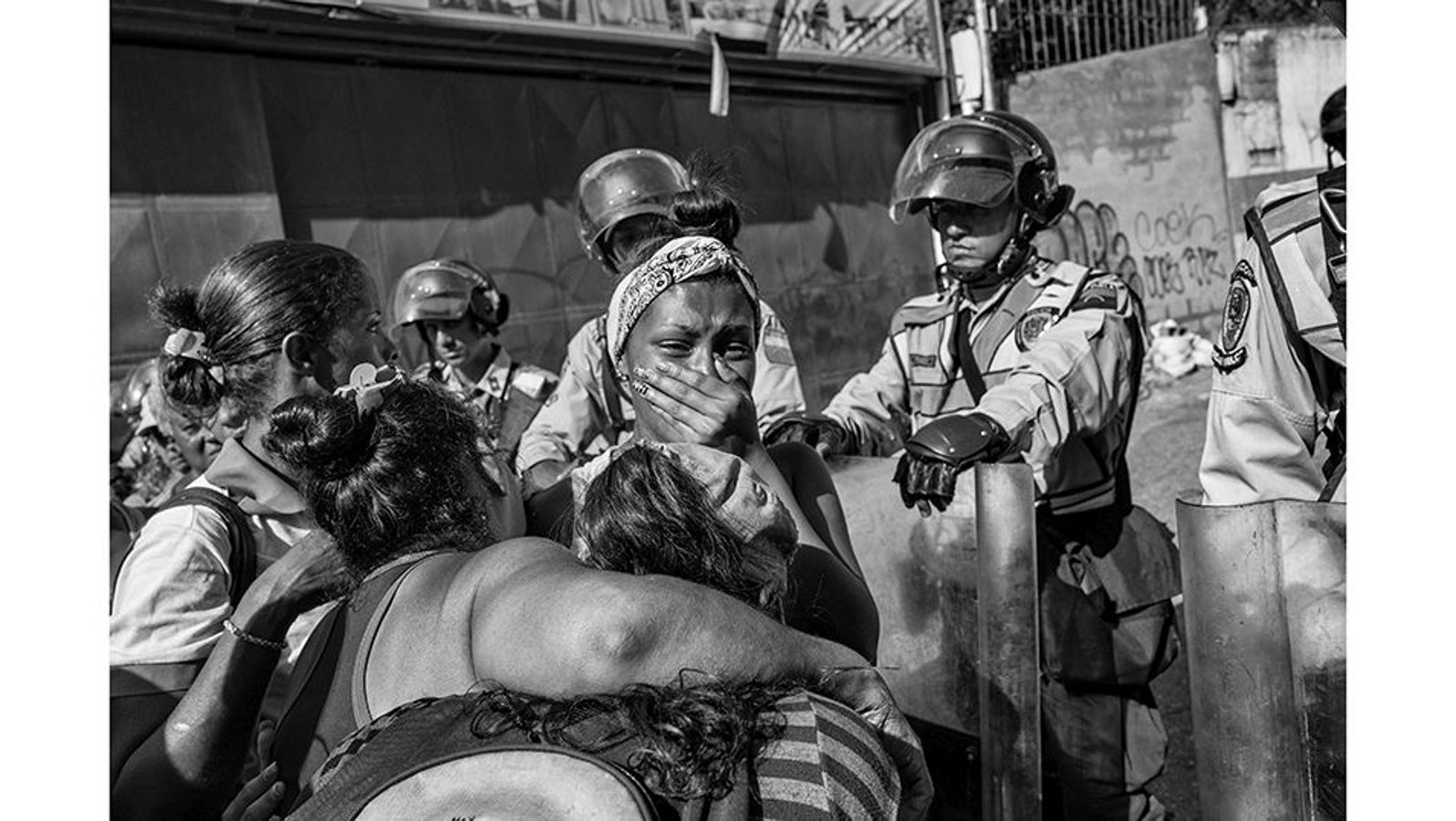 Caracas (Venezuela), 5 de junio de 2016. Una mujer llora frente a la policía por la angustia de no tener noticias de su hermano, uno de los 600 detenidos que se han amotinado dentro de la Comisaría de la Policía Nacional en la zona 7 de Los Ruices. En medio de una crisis económica, las cárceles de Venezuela sufren un hacinamiento crónico y los presos carecen de alimentos y medicinas adecuados. Los motines en las cárceles y comisarías se han vuelto frecuentes debido a las deplorables condiciones de detención