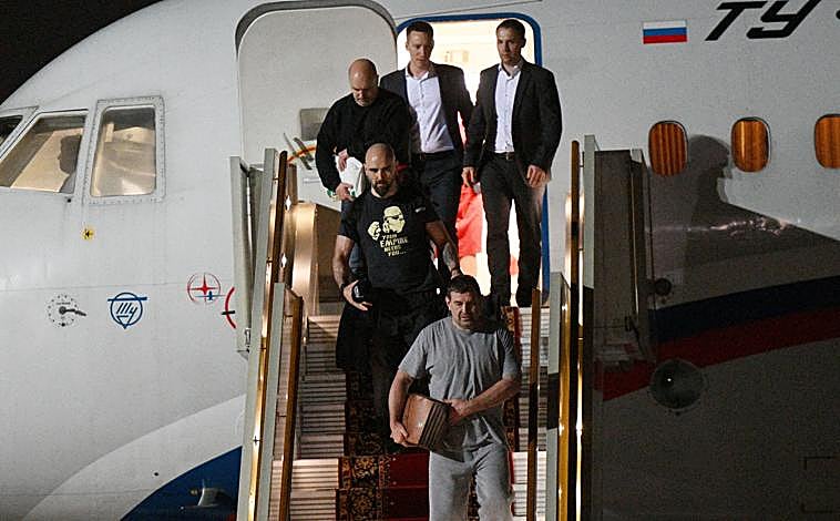 Imagen principal - En la foto de arriba se ve a Pablo González bajando del avión, con camiseta negra. Debajo, comitiva de prisioneros canjeados junto a Putin. En la foto pequeña, Pablo González al fondo, con camiseta negra
