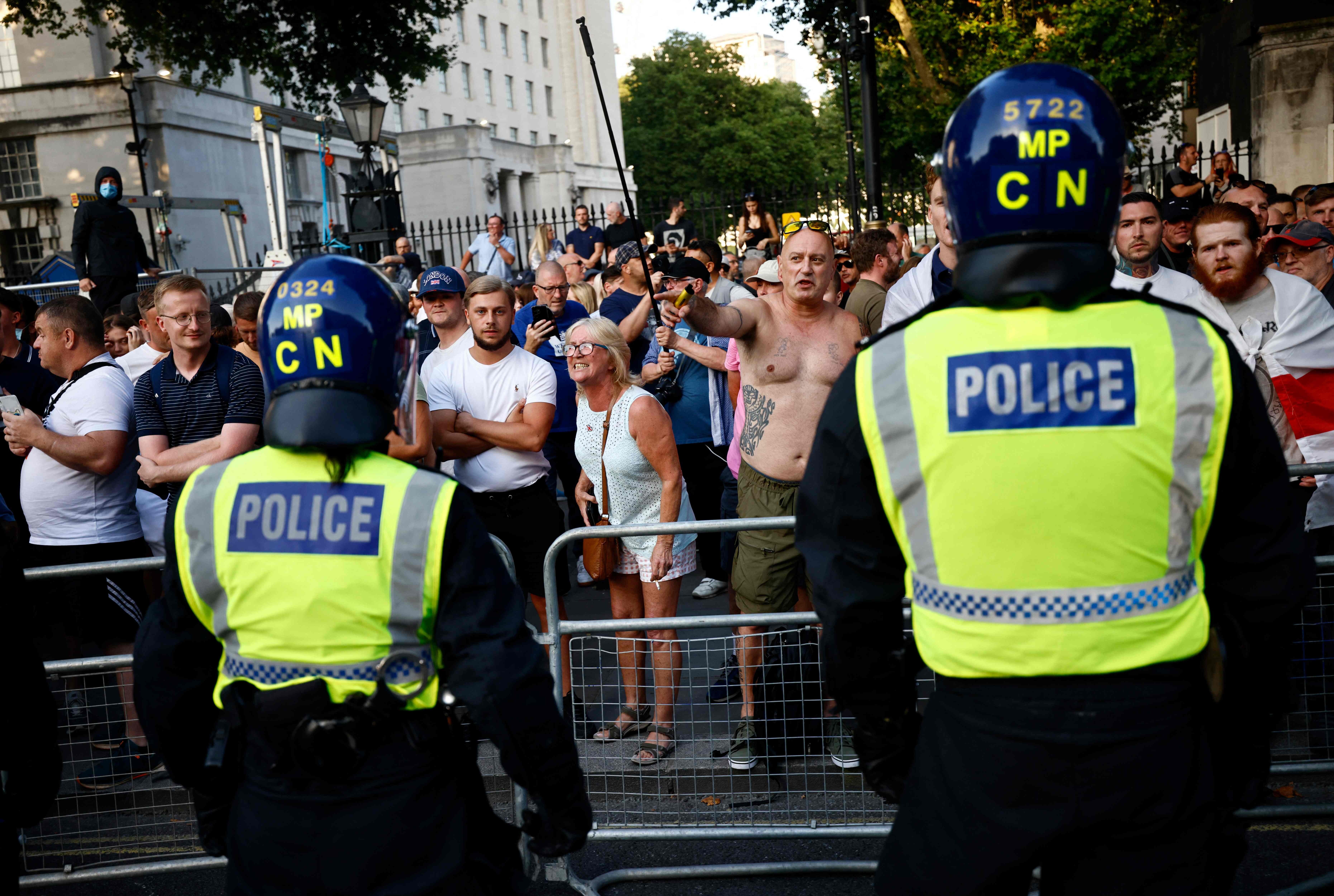 Dos agentes de la policía inglesa enfrente con los manifestantes