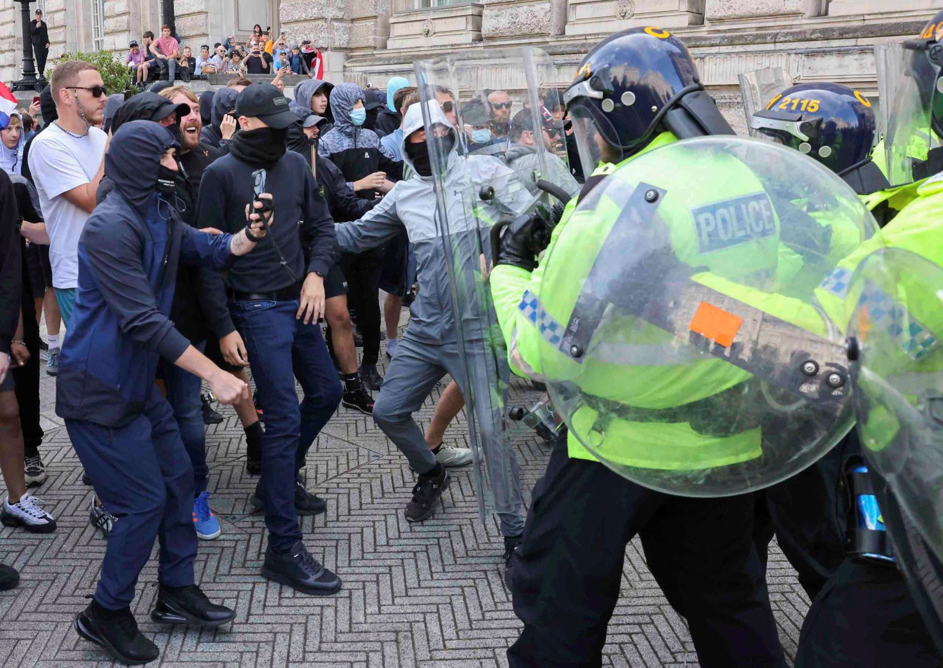Oficiales de policía y manifestantes se enfrentan durante la protesta en Liverpool contra la inmigración tras el asesinato de tres niñas.