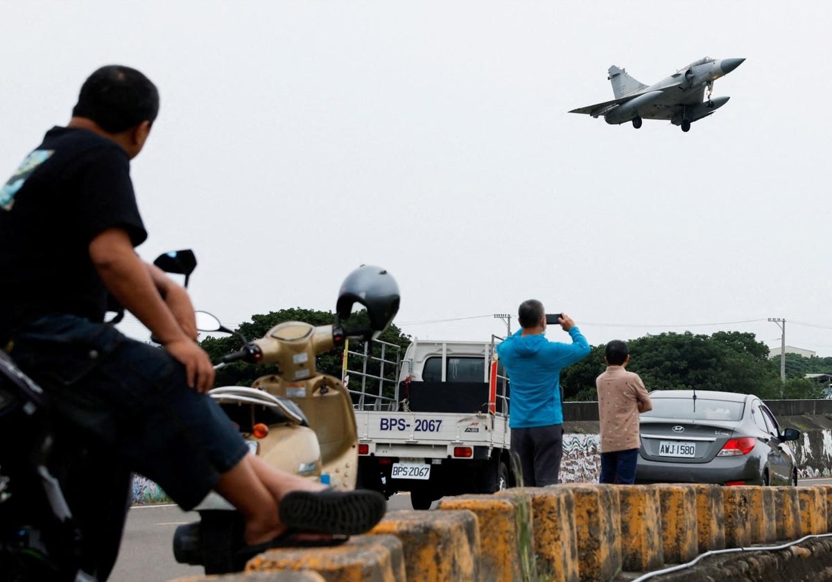 Personas observan un avión Mirage 2000-5 de la Fuerza Aérea taiwanesa que va a aterrizar en Taiwán