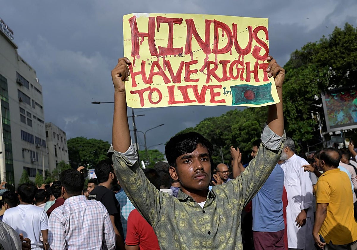 Un manifestante sostiene una pancarta en la que se lee «Hindús tienen derecho a vivir en Bangladés»