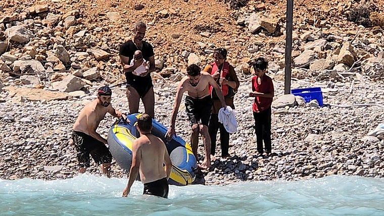 Los rescatistas llegan en bote a las rocas para auxiliar al bebé y a su familia