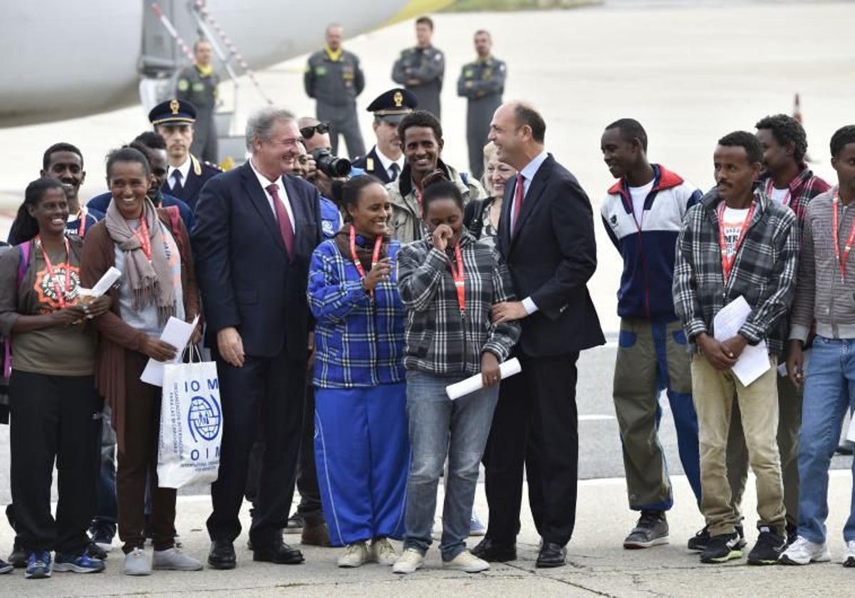Un grupo de refugiados eritreos, junto a dos diplomáticos, antes del despegue de su avión con destino a Suecia