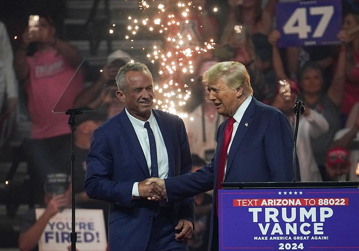 Robert F. Kennedy Jr. y Donald Trump estrechan sus manos.