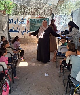 Imagen secundaria 2 - Desde que empezó la guerra de Gaza en octubre, más del 70 por ciento de las escuelas han resultado destruidas o dañadas. Sin libros, ni lápices, ni pupitres, ni pizarras, los 170 niños que estudian en las aulas improvisadas que dirige la profesora Jaldia al Hasheim intentan no perder su educación, ni su infancia, bajo las bombas del Ejército israelí
