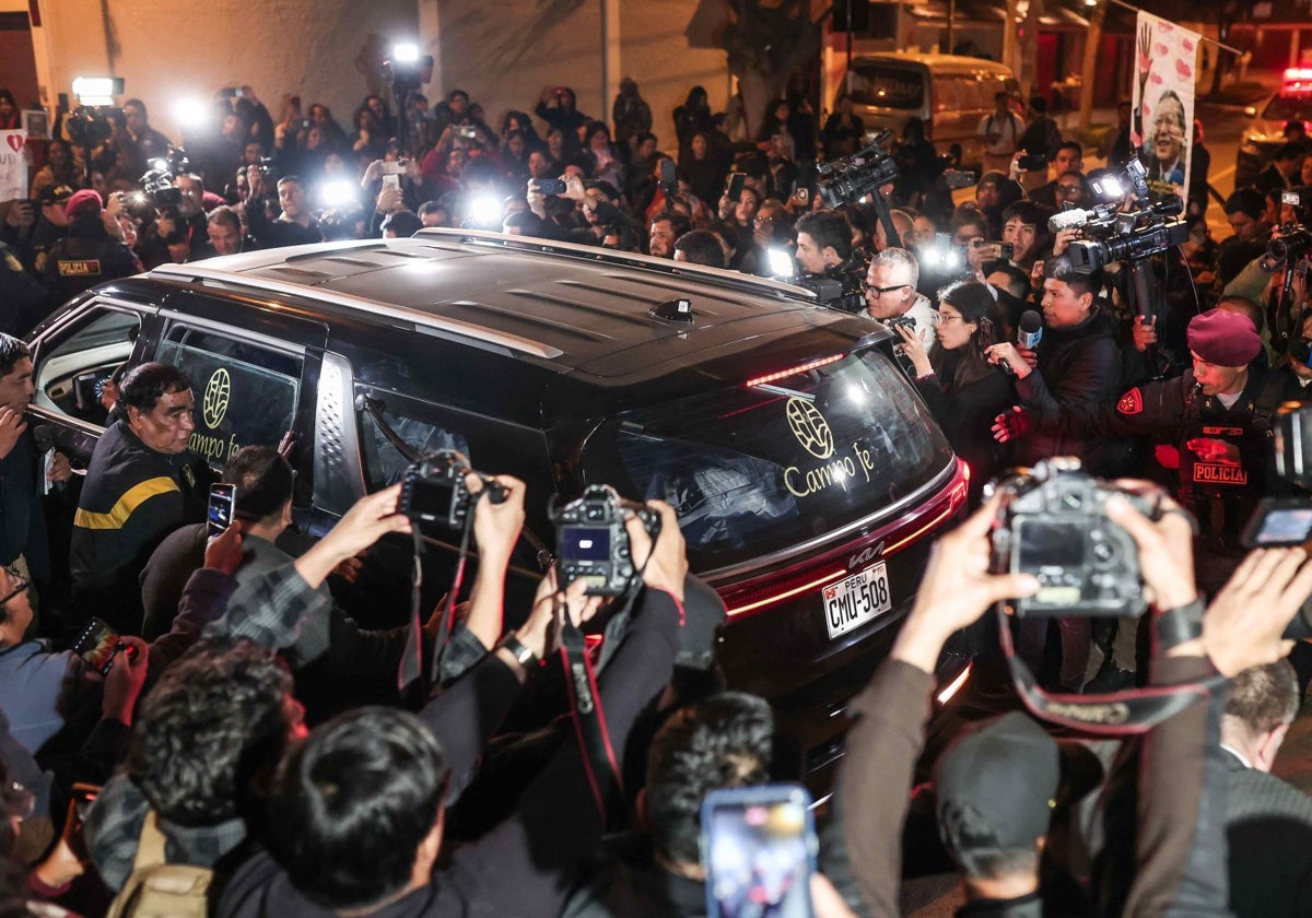 Los periodistas se arremolinan alrededor del coche fúnebre en Lima