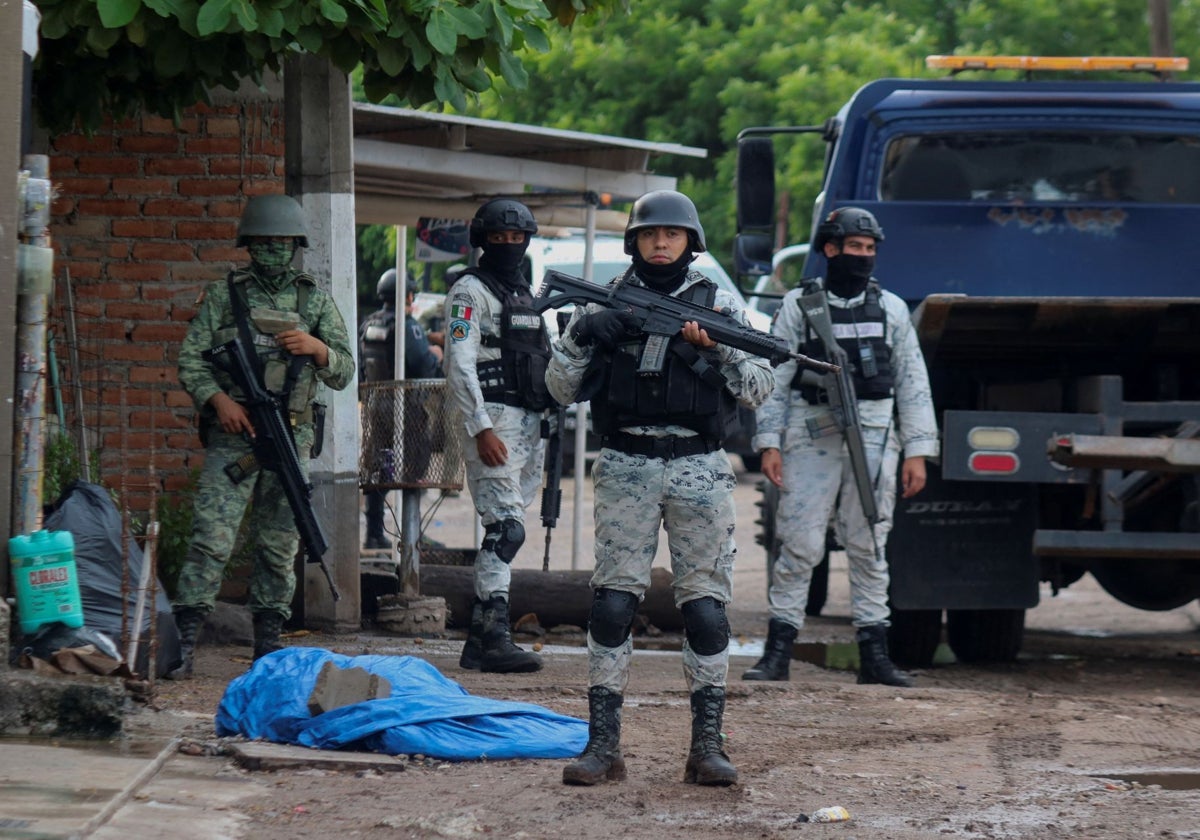 Fuerzas de seguridad custodian la escena de un crimen en medio de una ola de violencia entre grupos armados en Culiacán