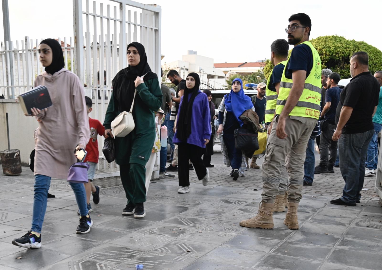 Numerosas personas desplazadas entrando en un refugio de un instituto en Beirut