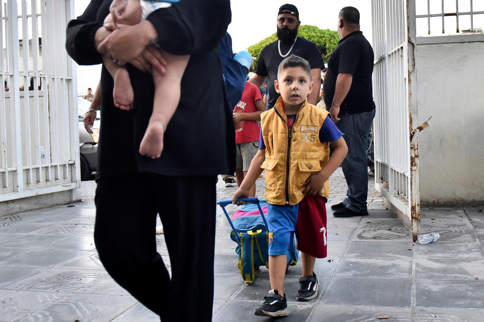 Numerosas familias llegando al refugio en un instituto de Beirut